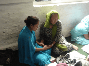 Una praying with a younger woman